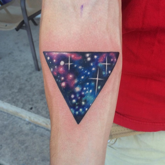 Simple designed colored triangle tattoo on forearm stylized with space