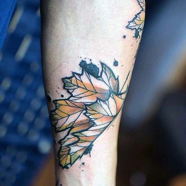 Simple designed little colored maple leaf tattoo on arm