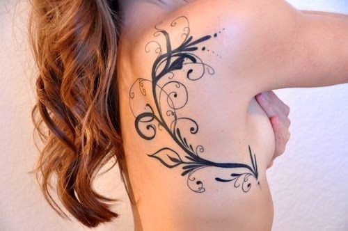 Tatuaje en el costado, tallo con hojas y rizos, tinta negra