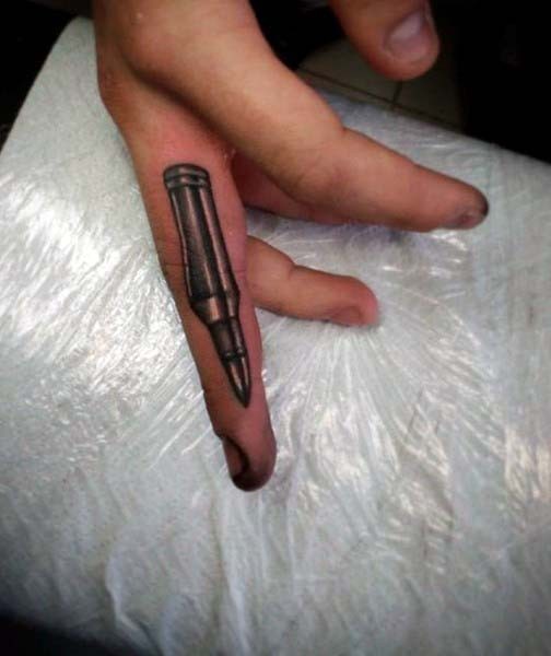 Simple detailed colored bullet tattoo on finger