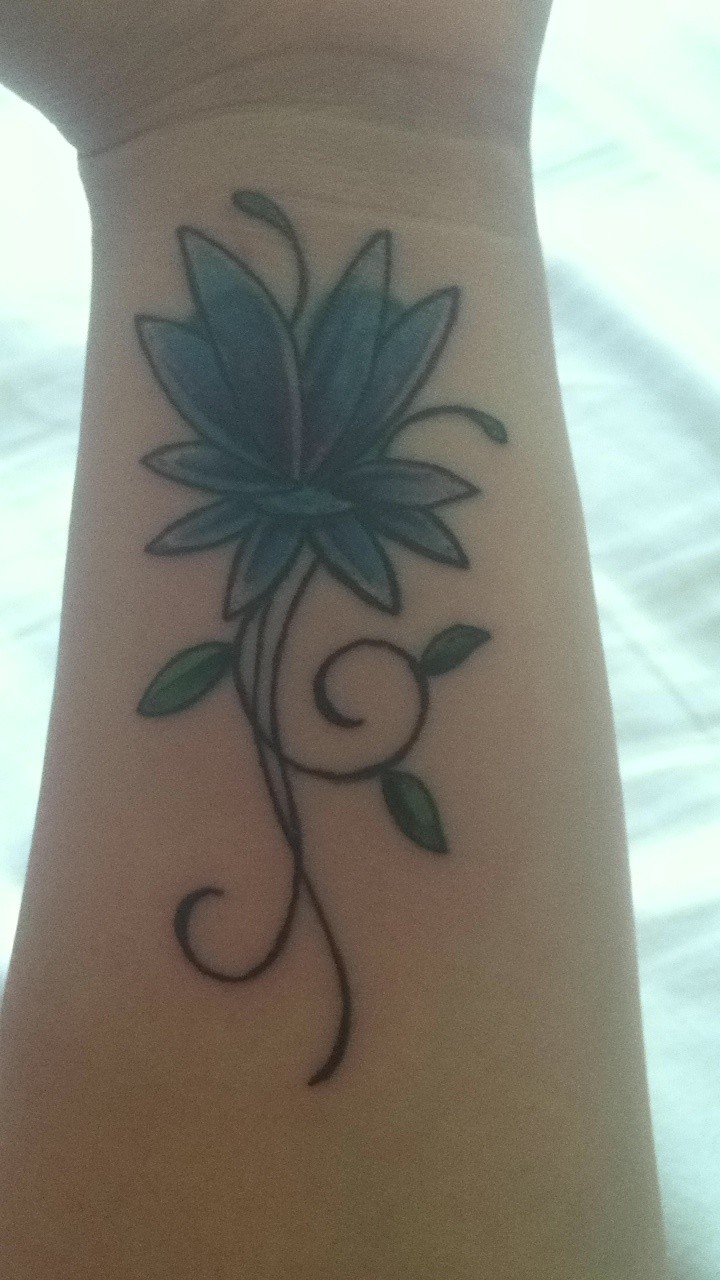 Tatuaje en la muñeca, flor sencilla azul
