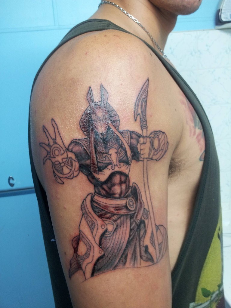 Simple homemade black ink Anubis God tattoo on shoulder