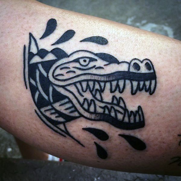 Tatuaje en el brazo,
caimán único de tinta negra