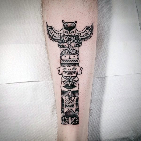 Simple homemade like black ink tribal statue tattoo on leg