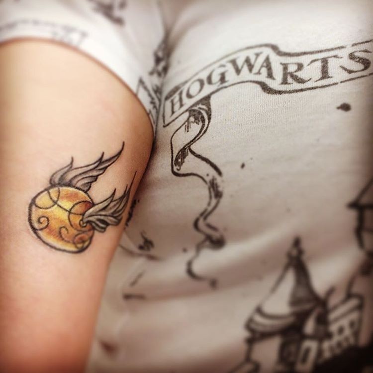 Simple homemade like colored beautiful quidditch ball tattoo on arm