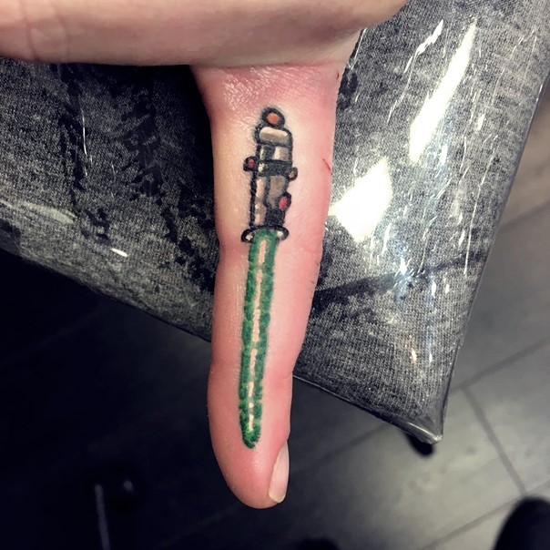 Simple homemade like tiny on finger tattoo of green lightsaber