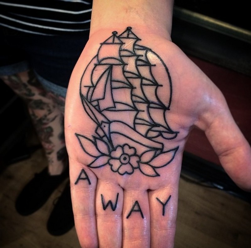 Simple homemade style black ink ship with flower with lettering tattoo on hand