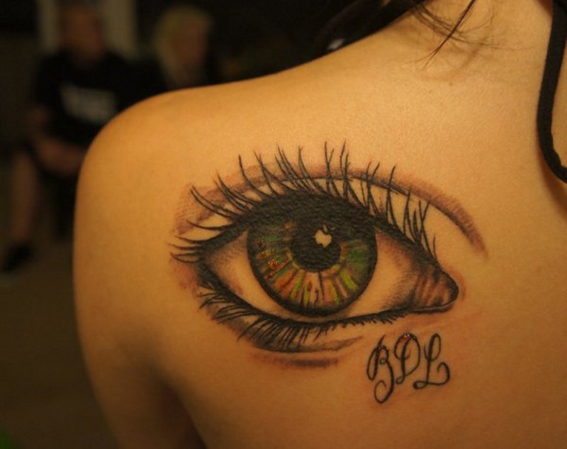 Tatuaje en el hombro, ojo sensual verde con iniciales