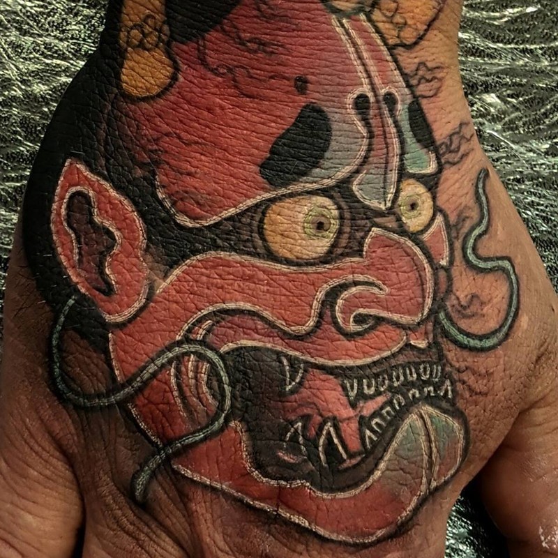 Simple illustrative style hand tattoo of demonic mask