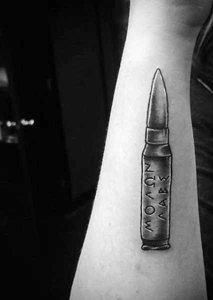 Simple little black and white bullet with Latin lettering tattoo on arm