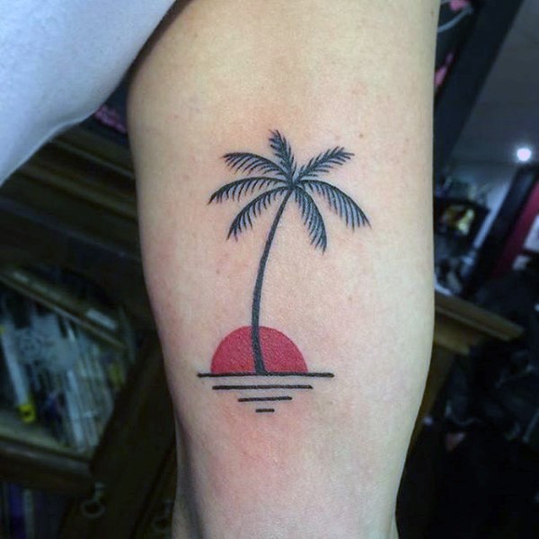 semplice piccolo inchiostro nero albero palma con sole rosso tatuaggio su braccio