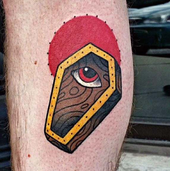 Tatuaje en la pierna, ataúd extraño con ojo y sol rojo