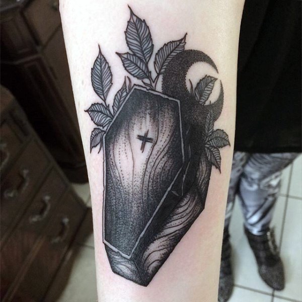 Einfacher kleiner Holzsarg mit Kreuz und Mond Tattoo am Arm