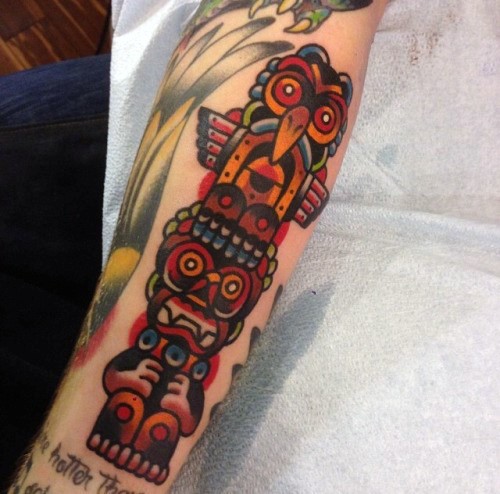 Einfache mehrfarbige alte Tribal Statue Tattoo am Arm