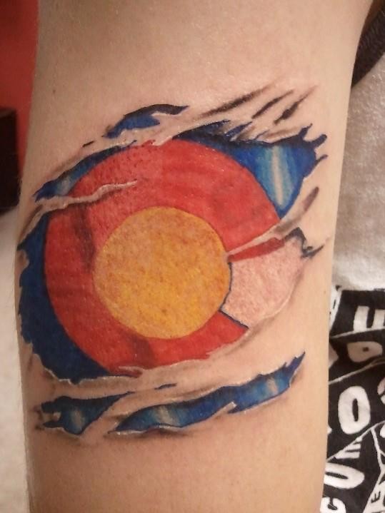 Simple multicolored arm tattoo of red and yellow circle