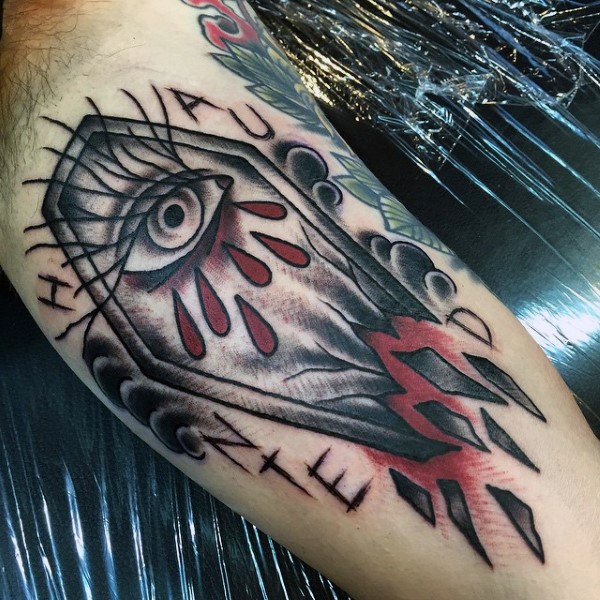 Tatuaje en el brazo, ataúd con ojo y gotas de sangre