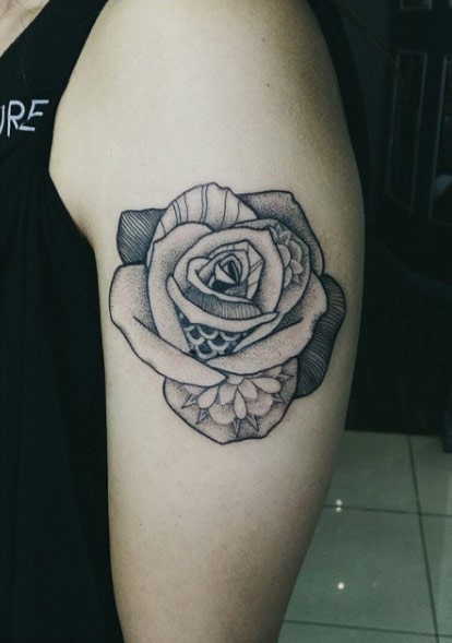 Tatuaje en el brazo,
rosa única decorada con flores