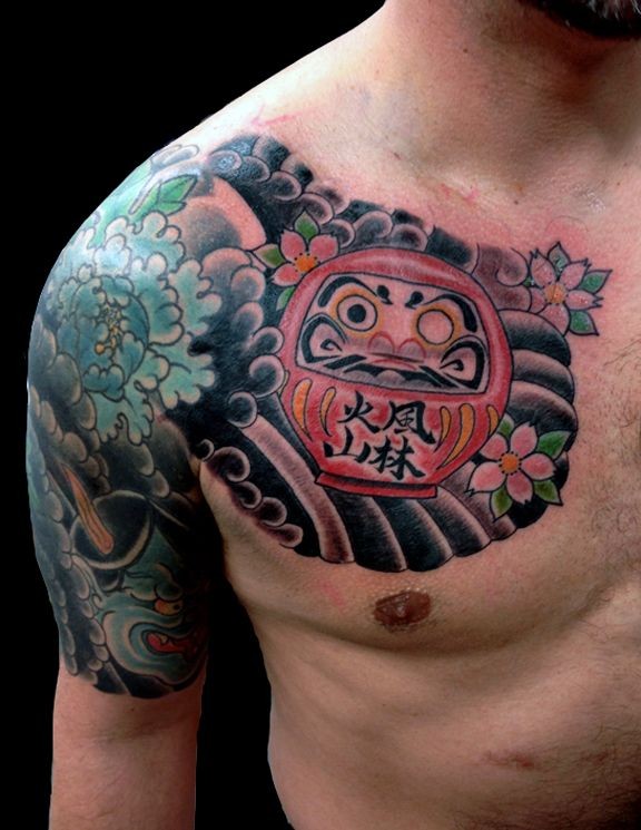 Simple old school style chest tattoo of daruma doll with flowers and waves