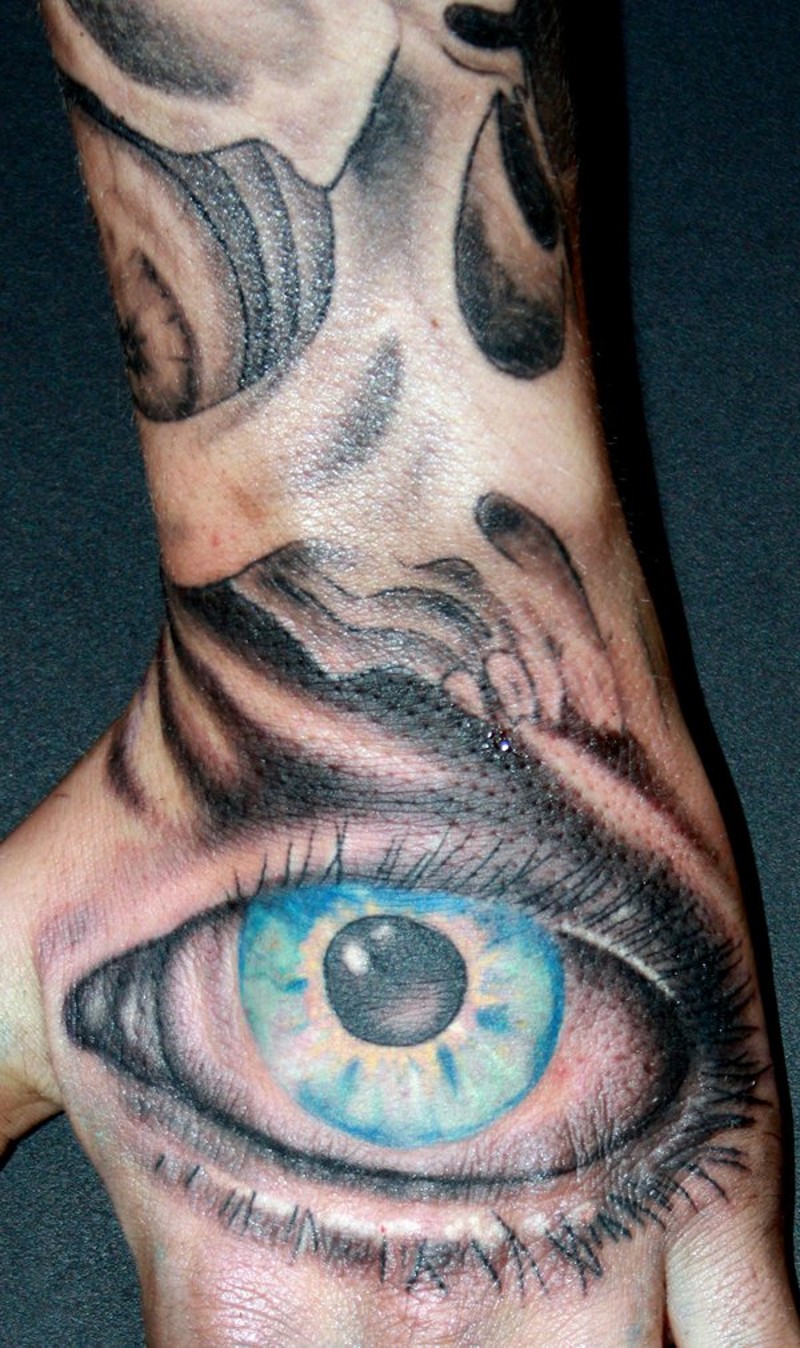 Simple painted big blue colored eye tattoo on hand