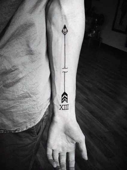 Simple painted black ink arrow with number tattoo on arm