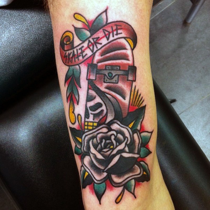 Simple painted colored skate board with lettering and flower tattoo on leg