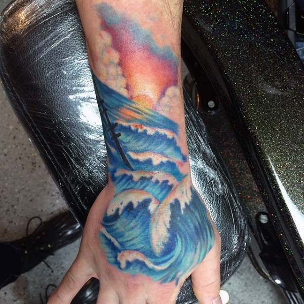 Simple painted colorful ocean waves with ship tattoo on wrist