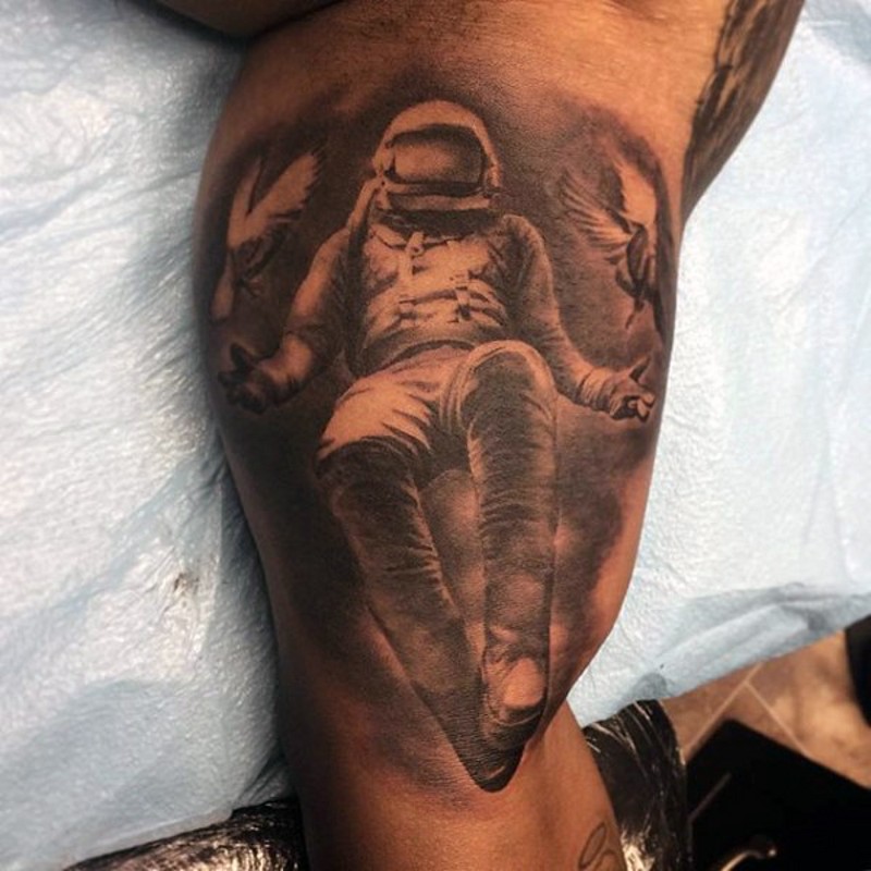 Simple realistic looking black ink astronaut with pigeons tattoo on arm