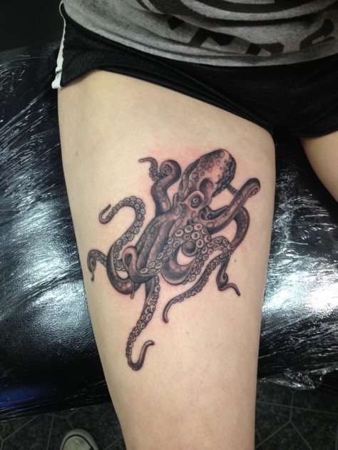 Simple tiny colored octopus tattoo on thigh