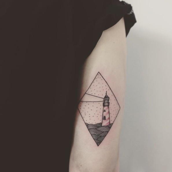 Tatuaje en el brazo,
faro simple en el mar, tinta negra