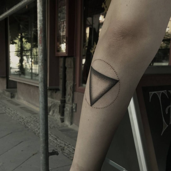 Simple vintage like colored triangle tattoo on forearm with circle