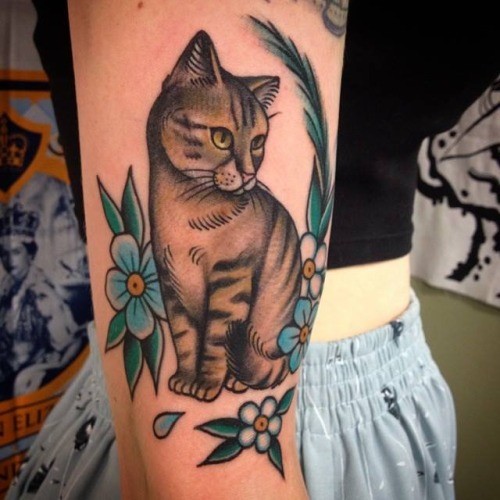 Tatuaje de gato grácil realista en el brazo