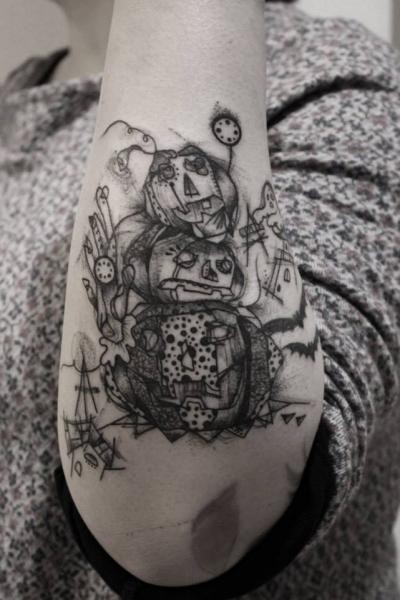 Sketch style black ink arm tattoo of creepy pumpkins
