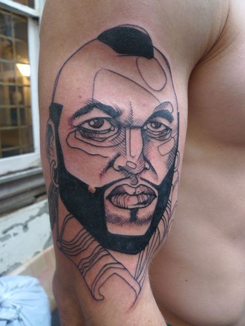 Sketch style black ink shoulder tattoo of famous actor face