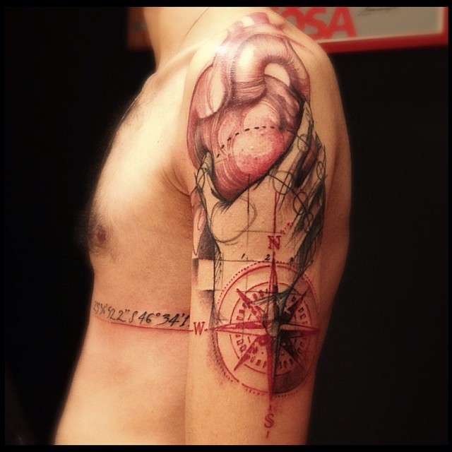 Sketch style colored shoulder tattoo of hand holding heart and compass
