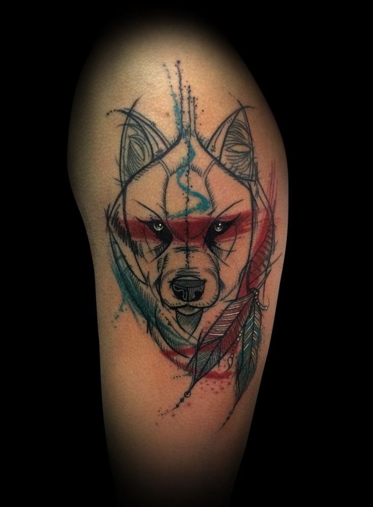 Sketch style colored upper arm tattoo of wolf with feather totem