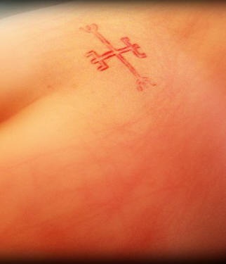 Skin scarification cross symbol