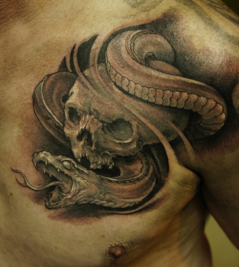 Black ink skull and snake tattoo on chest