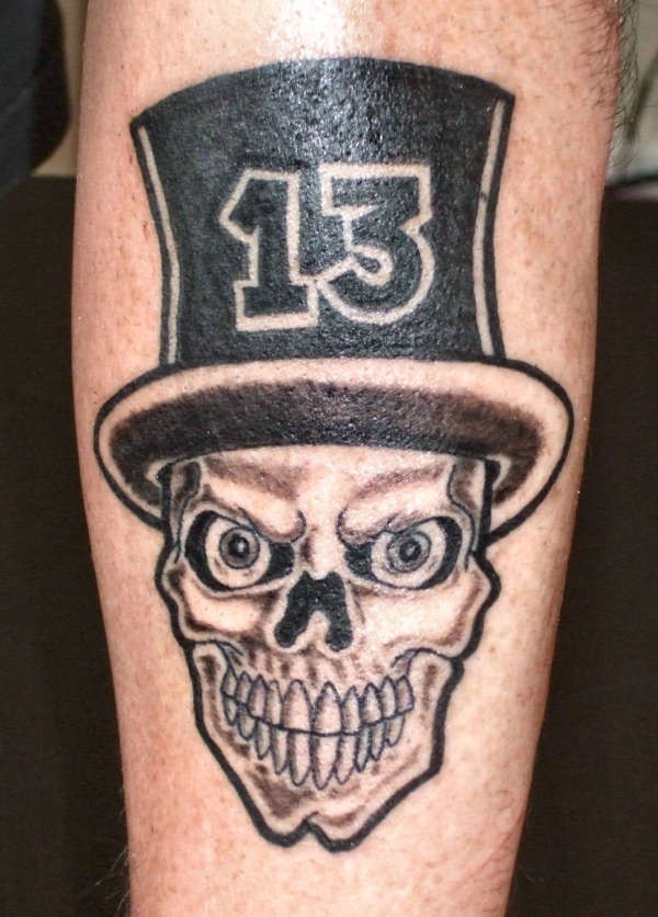 Skull in a hat with number thirteen tattoo