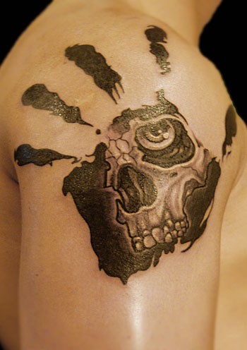 Skull in palmprints tattoo on shoulder