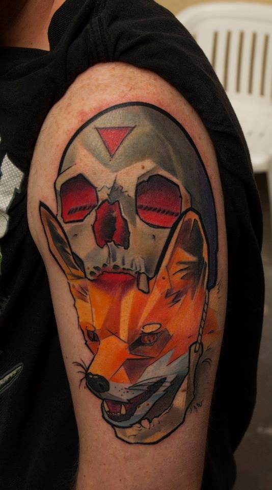 Tatuaje en el brazo, cráneo metálico con un zorro en la boca