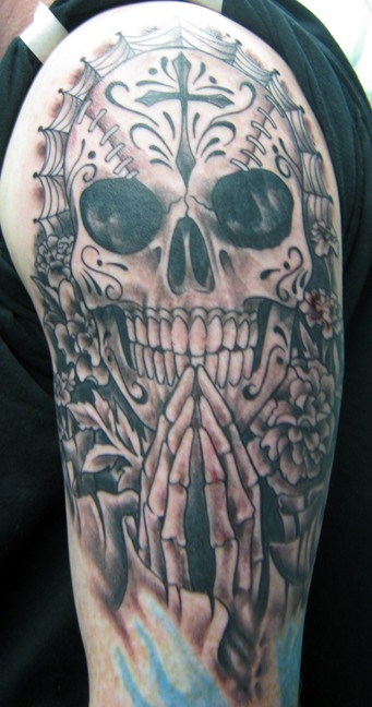 Tatuaje en el brazo, esqueleto con la cruz y montón de detalles