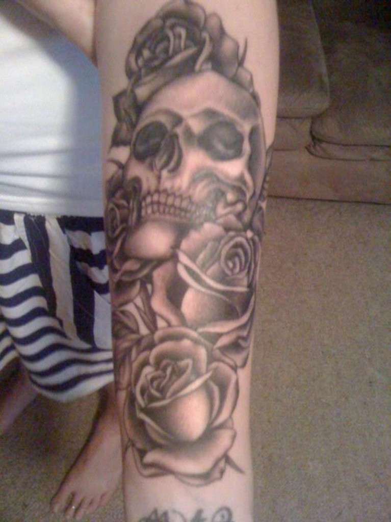 Skull with roses tattoo on forearm