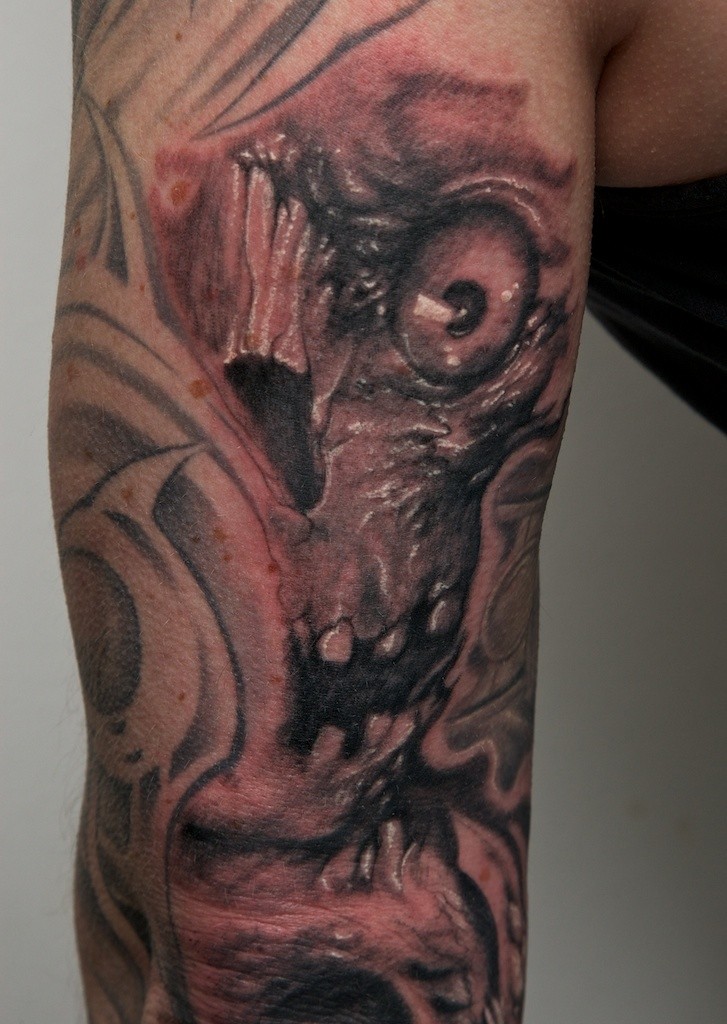 Tatuaje en el brazo, monstruo con la boca abierta