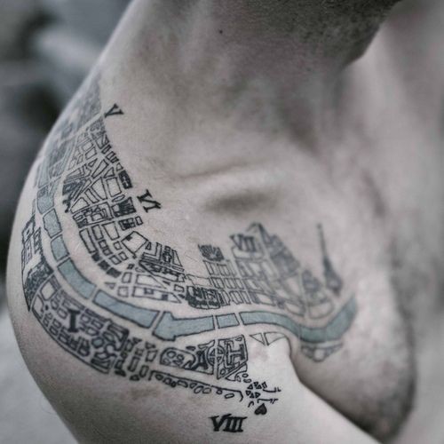 Slim colored city map like tattoo on shoulder stylized with numbers