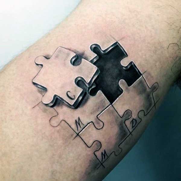 Small 3D style colored leg tattoo of puzzle pieces stylized with letters