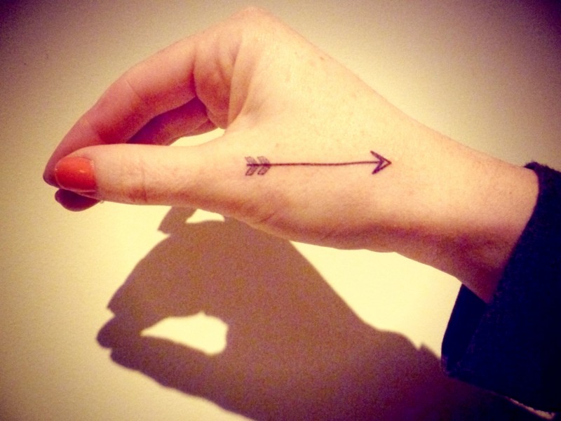 piccola freccia tatuaggio su mano di ragazza