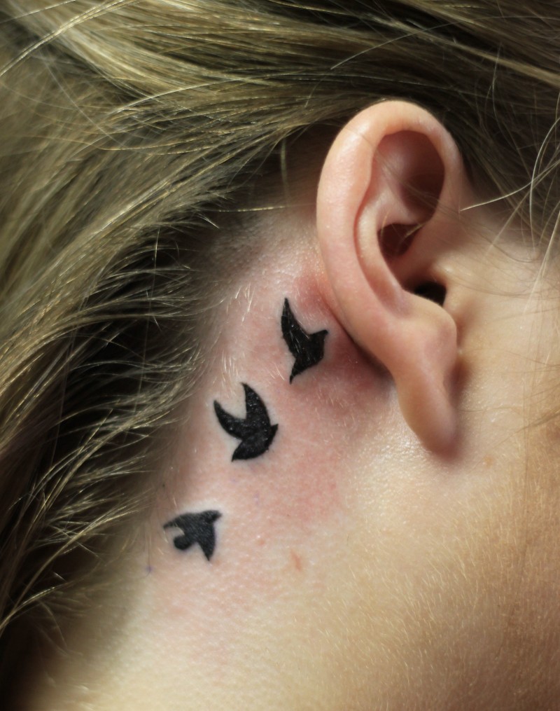 tre piccoli uccelli neri tatuaggio sotto orecchio per ragazze