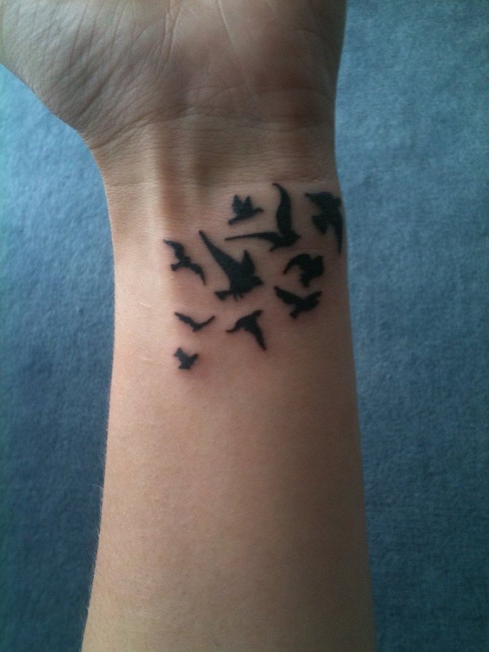 piccoli uccelli disegnato su polso tatuaggio