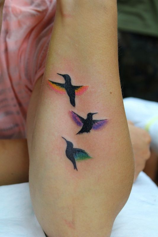 Tatuaje en el antebrazo,
aves con alas de colores diferentes