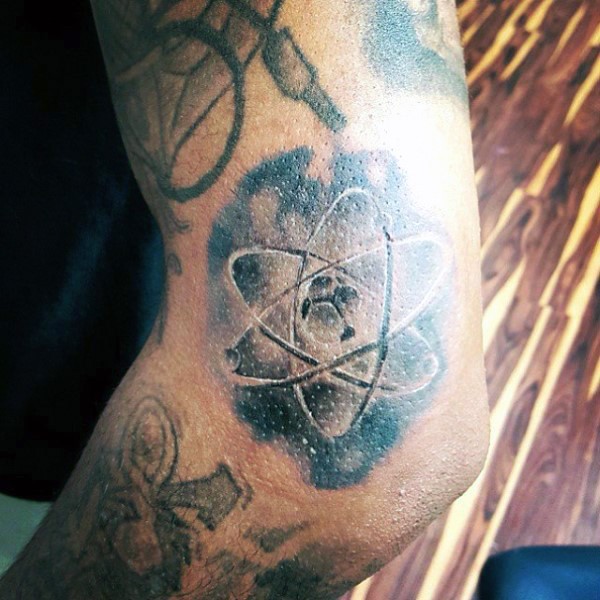 Small black and white elbow tattoo of small atom